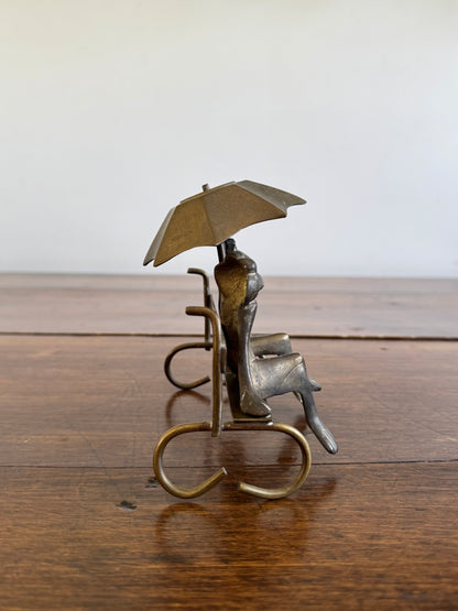 Vintage Brass Frogs Sitting on Bench Under Umbrella