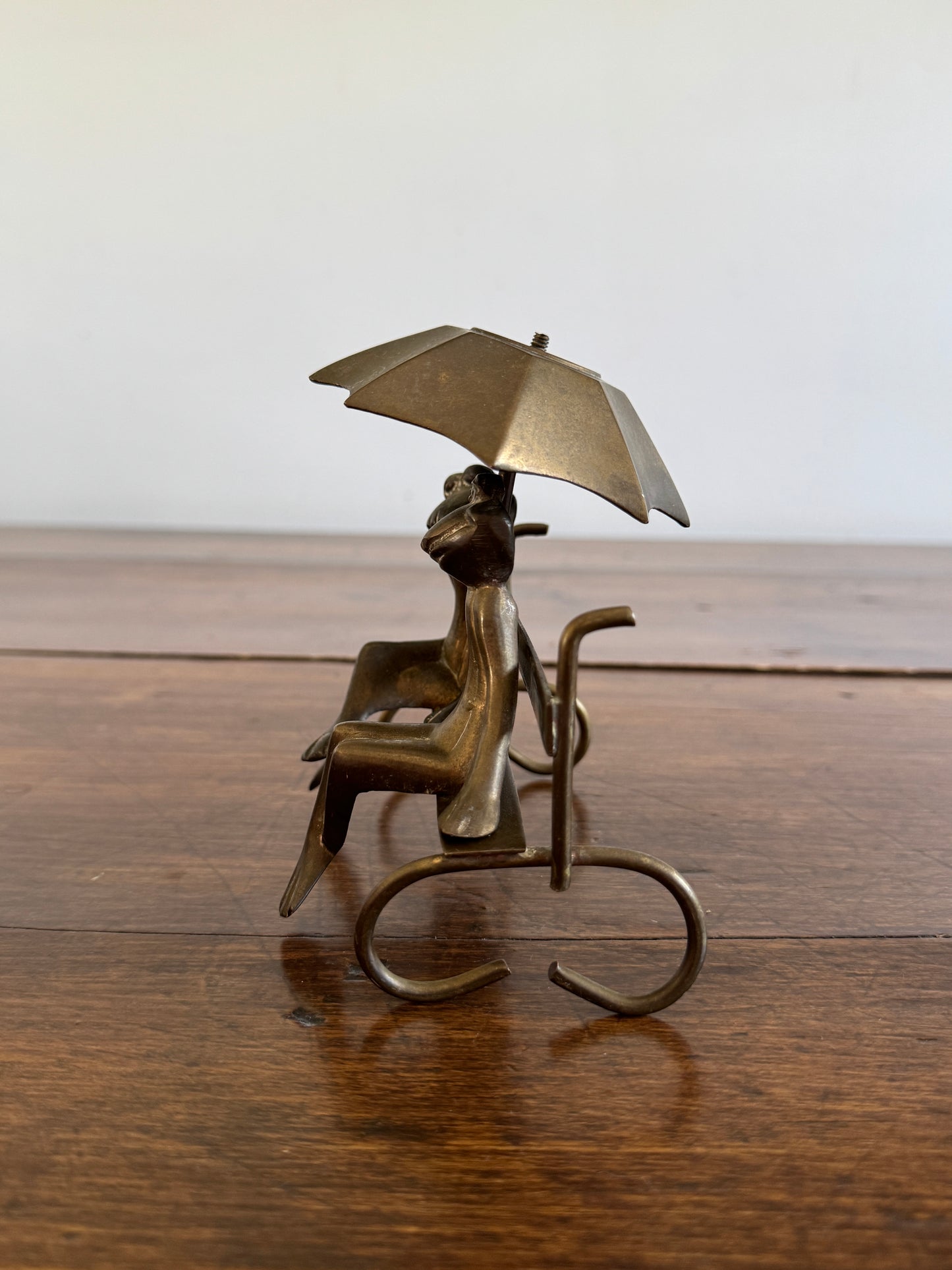 Vintage Brass Frogs Sitting on Bench Under Umbrella
