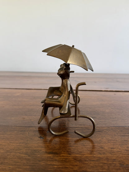 Vintage Brass Frogs Sitting on Bench Under Umbrella