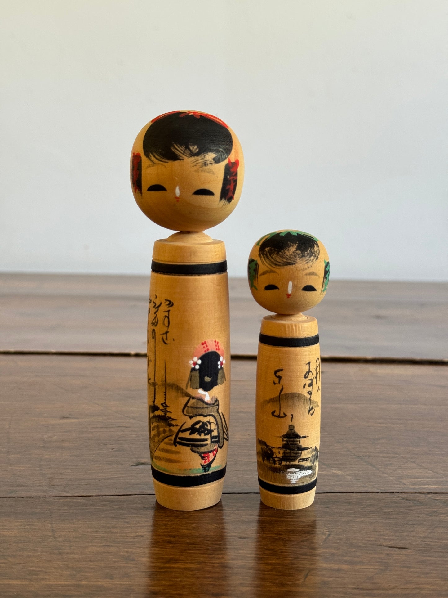 Vintage Pair of Japanese Kokeshi Dolls with Scenic Bodies and Calligraphy