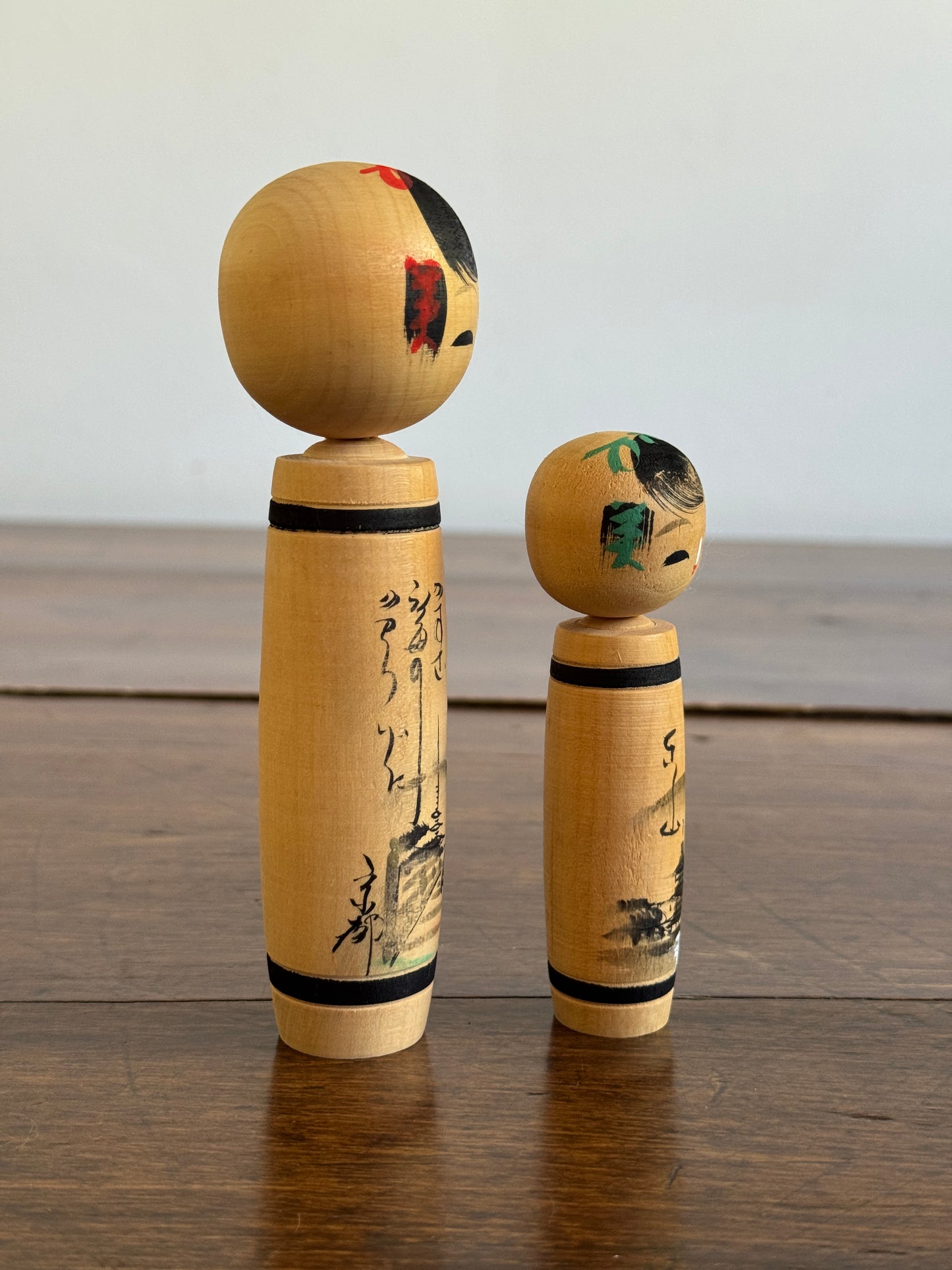 Vintage Pair of Japanese Kokeshi Dolls with Scenic Bodies and Calligraphy