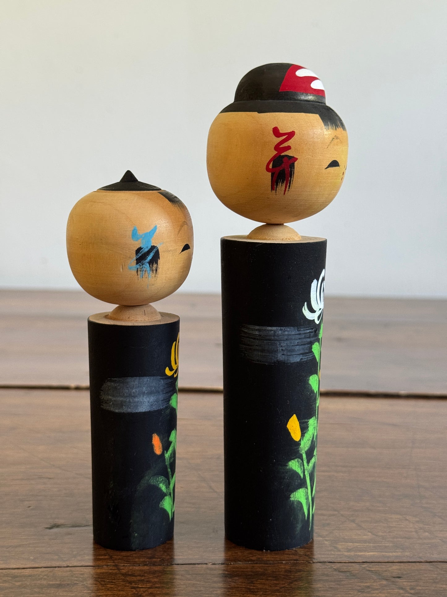 Two Japanese Dolls in Black with Hand Painted Florals