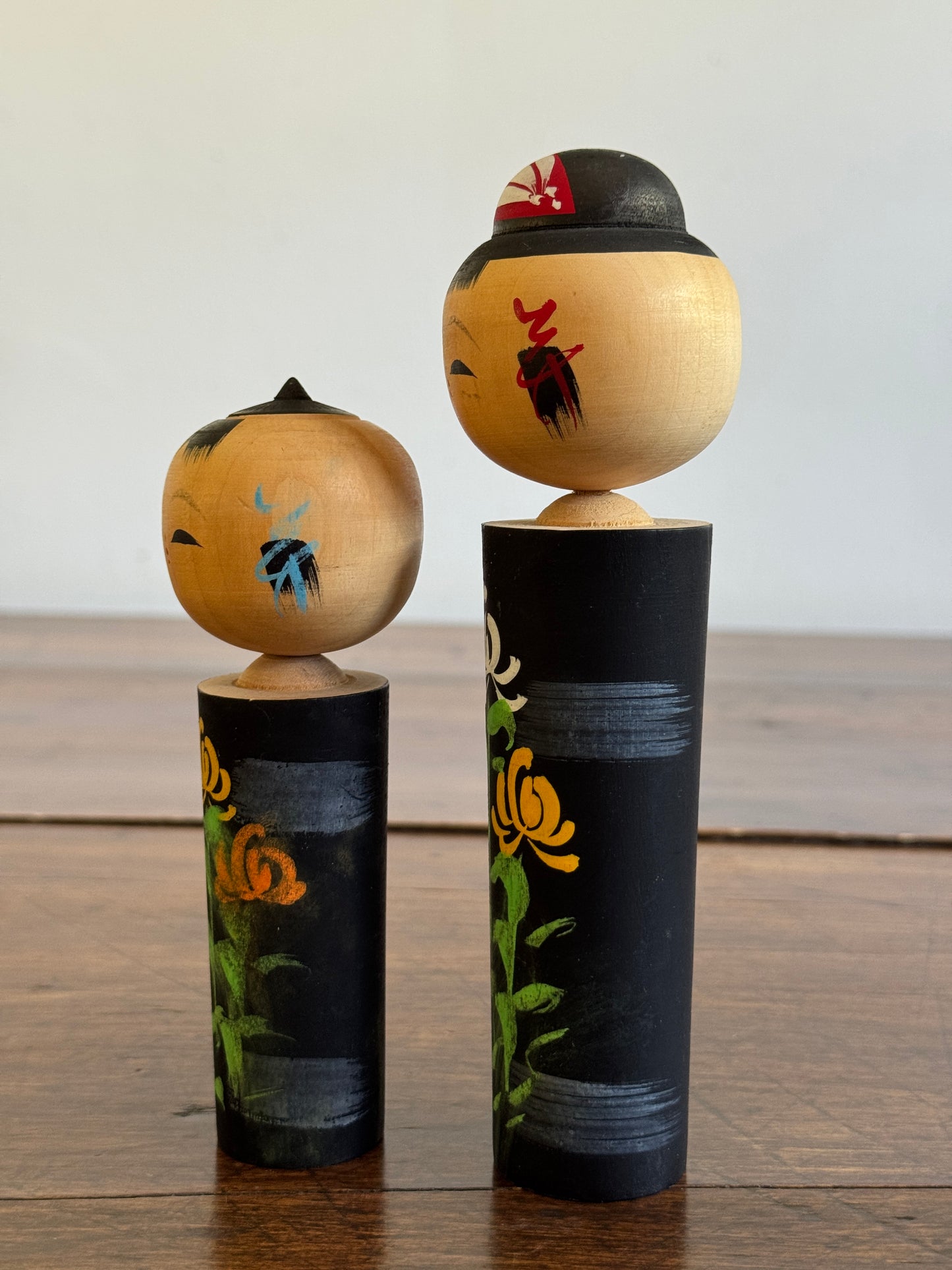 Two Japanese Dolls in Black with Hand Painted Florals
